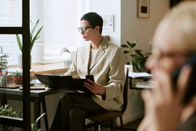 Advisor reviewing documents by a window